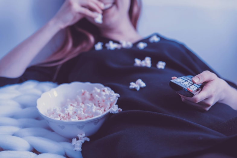 Femme mangeant du pop-corn en regardant un film | Justbob