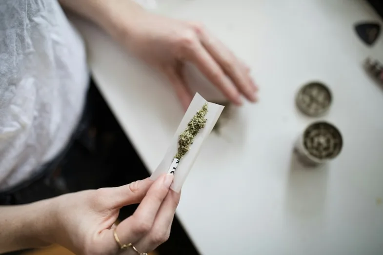 Joint de cannabis allumé en gros plan illustrant le contexte de consommation associé aux risques psychiques évoqués par les institutions sanitaires